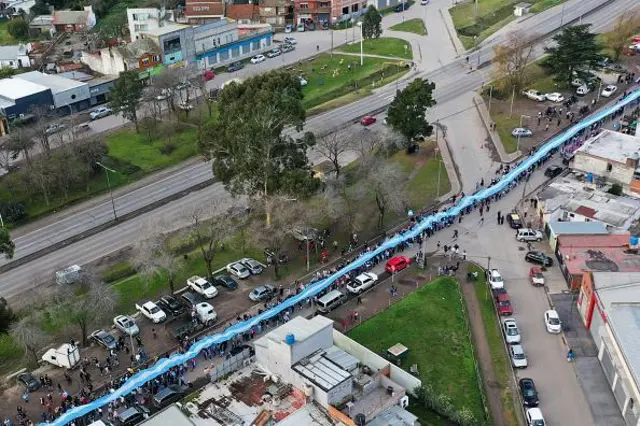 Cette vue aérienne montre des personnes déployant un drapeau national argentin géant dans les rues de Batan, dans la banlieue de Mar del Plata, dans la province de Buenos Aires.