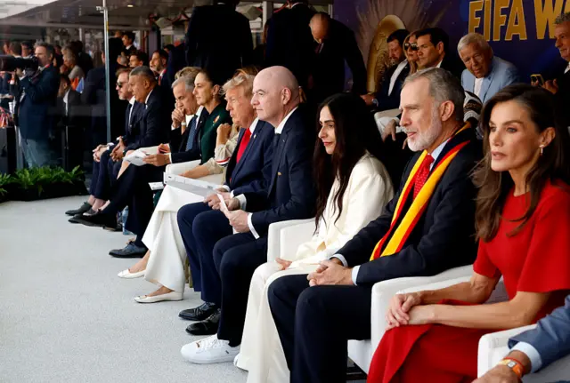 Líderes en el palco presidencial miran el partido