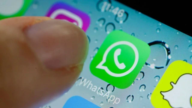 Ifoto igaragaza WhatsApp iri muri telefone n'igikumwe cy'umuntu ugiye kuyifungura