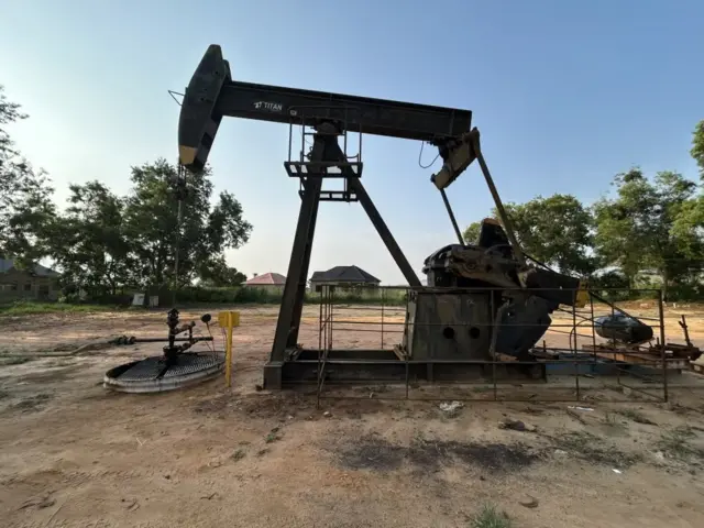 Imashini nyinshi zirimo n’itendetse hejuru za kompanyi Perenco muri Repubulika ya Demokarasi ya Congo. Inyuma kure hari inzu nyinshi n’ibiti.