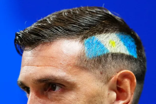 Dibu con la bandera de Argentina en el pelo