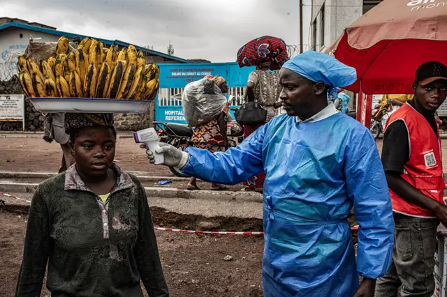 Umukozi wo mu rwego rw’ubuvuzi arimo gupima umuriro umugore, mu ngamba zo kurwanya Ebola, i Goma mu burasirazuba bwa Repubulika ya Demokarasi ya Congo, ku itariki ya 24 Kamena (6) mu 2026.