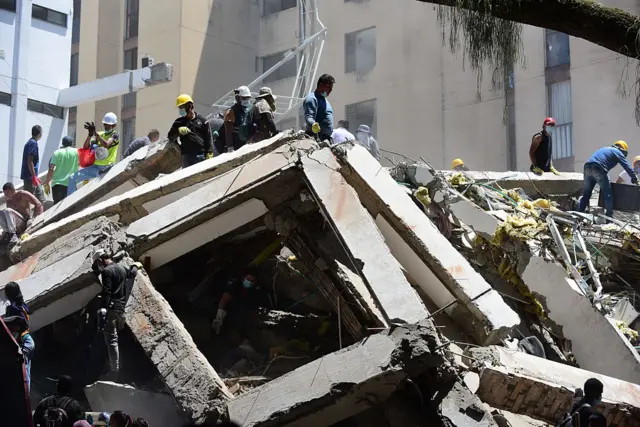Equipos de emergencia llevan a cabo operaciones de búsqueda, rescate y evacuación en Cali. Se ven edificios derrumbados.