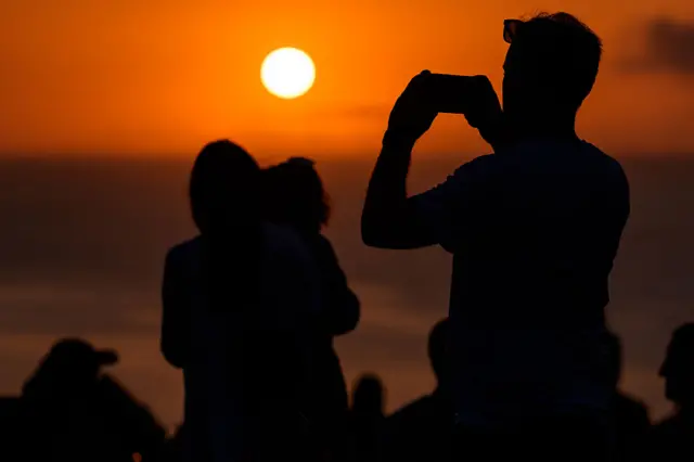Varias personas observan un atardecer en España