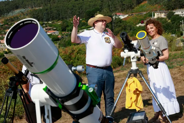 Dos astrónomos con varios telescopios profesionales