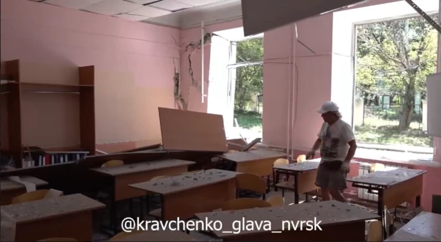 Мужчина среди парт, покрытых мусором после удара.