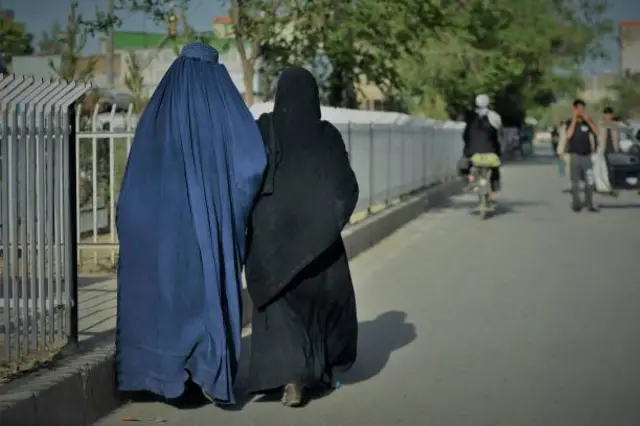 تصویر دو زن که یکی چادری پوشیده و دیگری چپن سیاه
