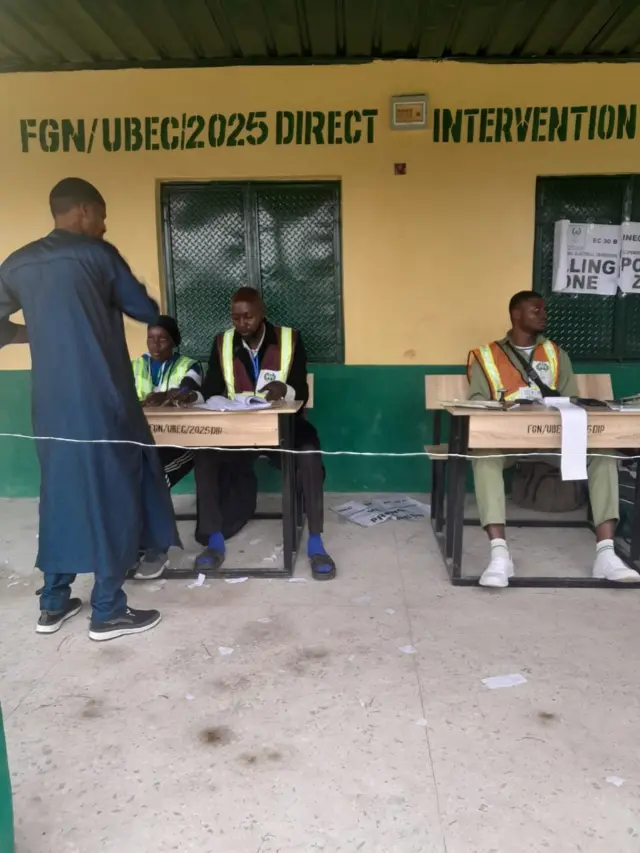 Three Inec officals siddon for bench wit one pesin wey be like voter stand for dia front