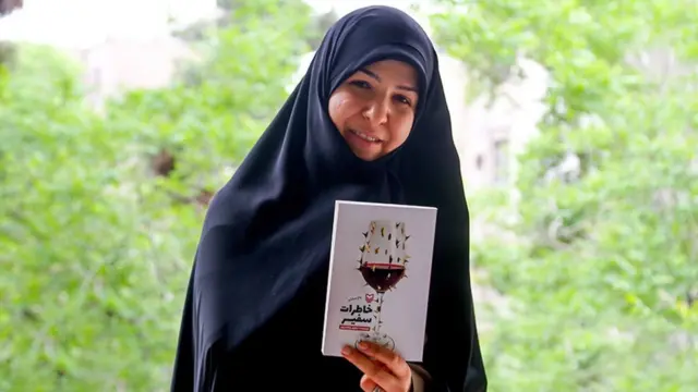 نیلوفر شادمهری با چادر سیاه و کتاب خاطرات سفیر در دست