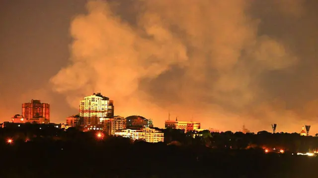 Ifoto igaragaza umwotsi uzamuka ahantu hangijwe inyubako i Kyiv.