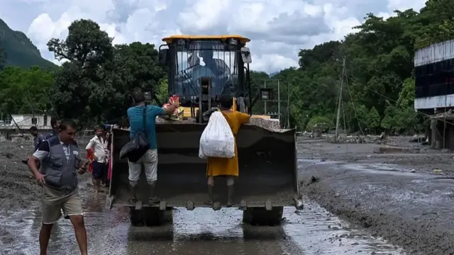 নেপালের নুয়াকোট জেলার দেবীঘাট এলাকায় উদ্ধারকারীরা বুলডোজার ব্যবহার করে আটকে পড়া বাসিন্দাদের অন্যত্র নিয়ে যাচ্ছেন