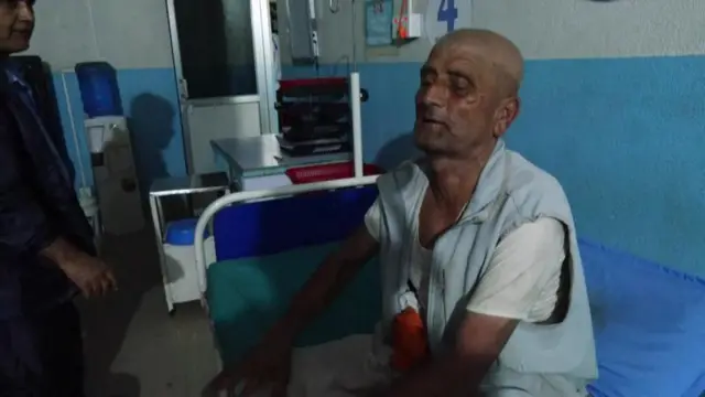 Homem sentado em maca de hospital