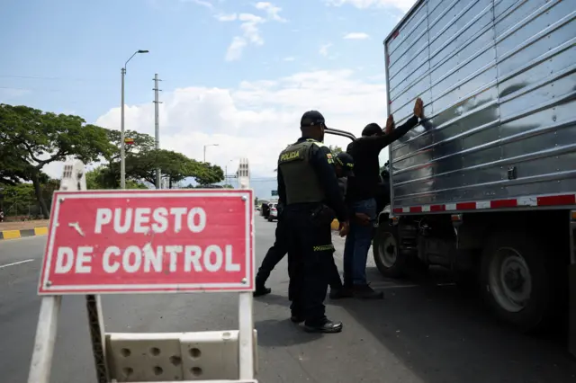 Policías registran a un conductor en un puesto de control