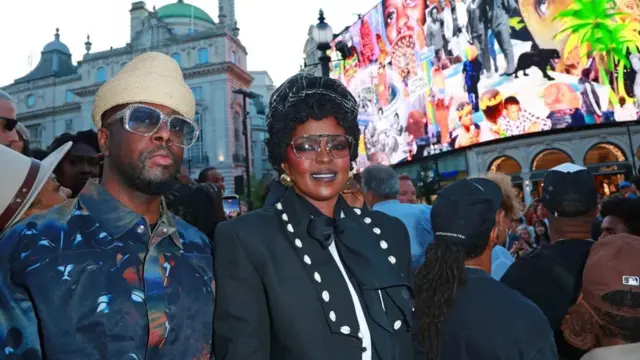 Wyclef Jean na Lauryn Hill bariko barifotoza bahagaze imbere y'isinzi ry'abantu.