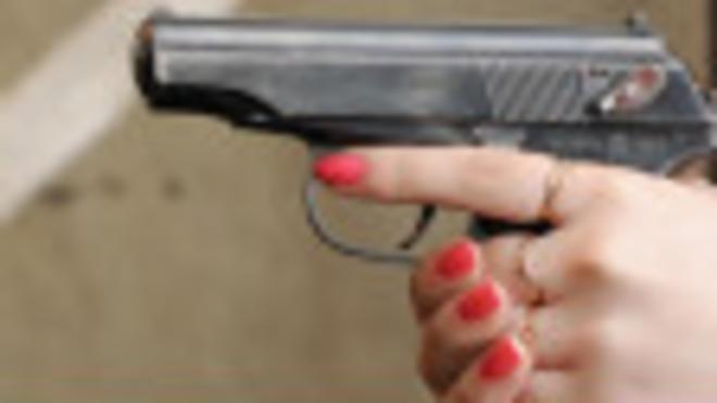 Женщина стреляет из пистолета