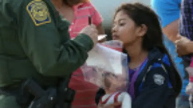 Agente fronterizo toma los datos de una niña inmigrante salvadoreña.
