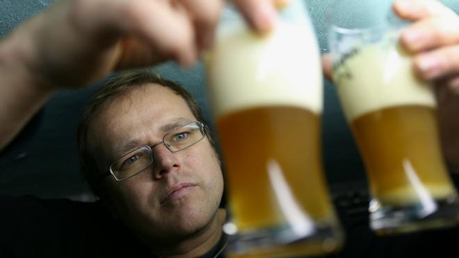 Un experto examina dos vasos con cerveza