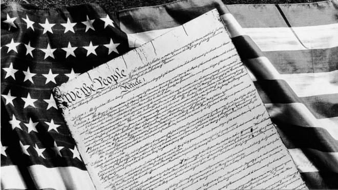 Конституция США на фоне американского флага