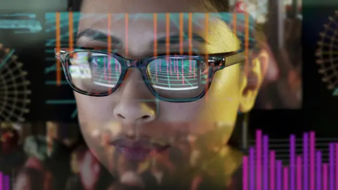 Close up stock photo of a girl studying moving data on her computer screen