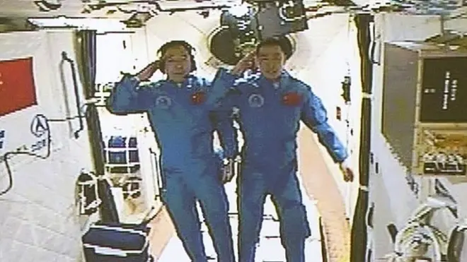 State television carried live video showing Jing Haipeng (L) and Chen Dong waving as they entered the Tiangong space lab