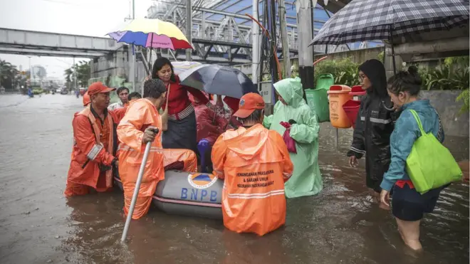 Sejumlah warga Jakarta harus menumpang perahu karet untuk berangkat ke kantor, pada Selasa (21/02) pagi.