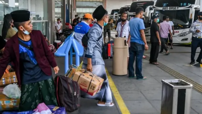 Calon penumpang bersiap menaiki bus di Terminal Terpadu Pulo Gebang, Jakarta, Jumat (26/03)