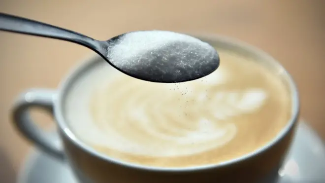 Spoon of sugar with coffee