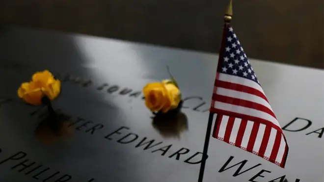 An American flag stands amongst names on the 9/11 memorial before the start of the 15th anniversary memorial service to 9/11 victims in New York, New York, USA,