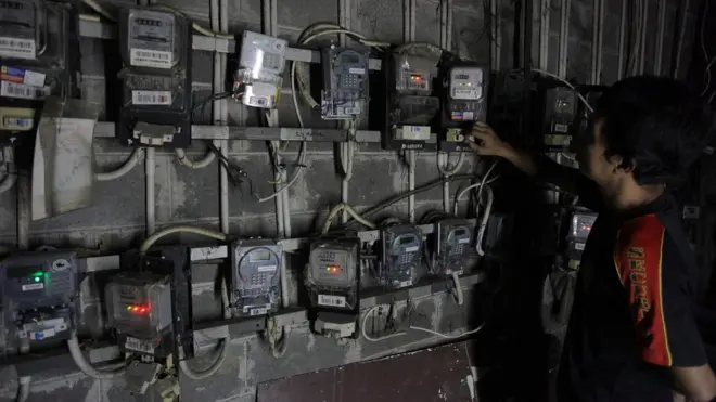 Seorang warga memeriksa meteran listrik di kompleks rumah susun (Rusun) Petamburan, Jakarta, Minggu (07/06).