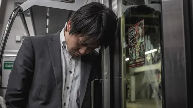 Seorang pria Jepang tertidur di kereta yang membawanya pulang ke rumah setelah seharian bekerja. Adalah hal yang normal bagi para pekerja di Jepang untuk menumpang kereta terakhir ke rumah setiap malam.