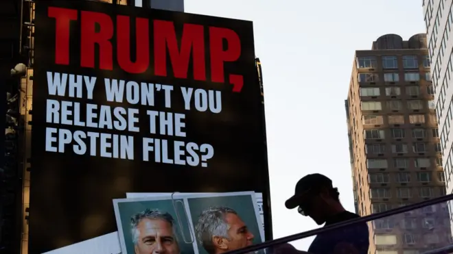 Плакат с надписью "Трамп, почему бы тебе не обнародовать дело Эпштейна" на стене здания