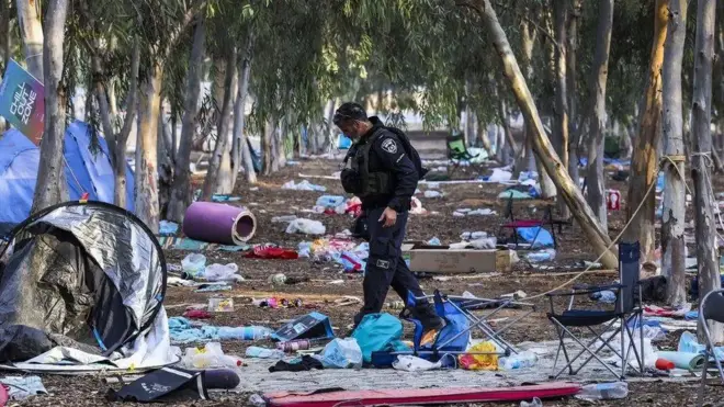 Policial caminhando pelo local onde foi realizado o festivalacima abaixo apostamúsica,acima abaixo apostameio a lixo, restosacima abaixo apostabarracas e colchonetes