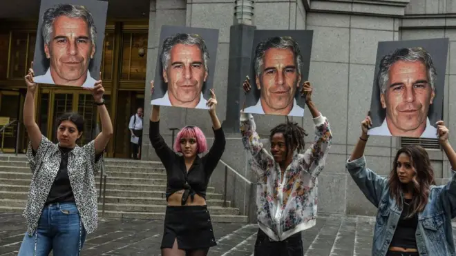 چند معترض عکسهای جفری اپستین را در دست بالا گرفتهاند