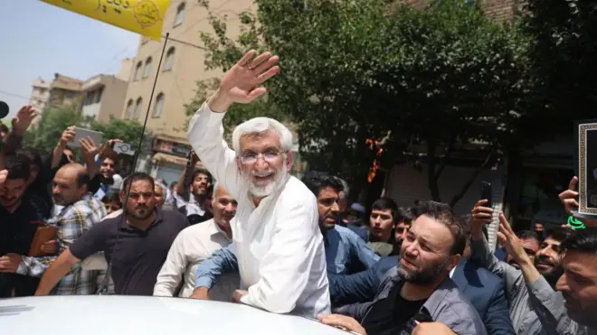 سعید جلیلی بعد از رای دادن در روز جمعه ۸ تیتر ۱۴۰۳ برای هوادارانش دست تکان می‌دهد