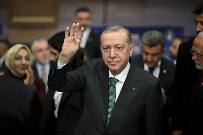 Erdoğan üstünde takım elbiseyle rabia selamı vererek yürüyor