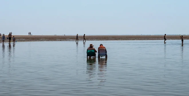 Un vieux couple assis à la plage