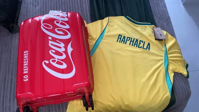 Kit da Coca-Cola com mala vermelha e camisa da seleção brasileira.