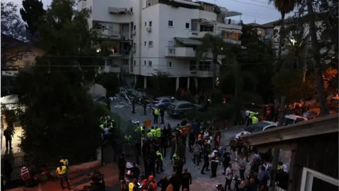 قوات أمن إسرائيلية ومسعفون يتجمعون أمام إحدى المباني في رحوفوت جنوبي تل أبيب التي سقط عليها أحد الصواريخ التي أطلقت من غزة وأسفر عن مقتل إسرائيلي