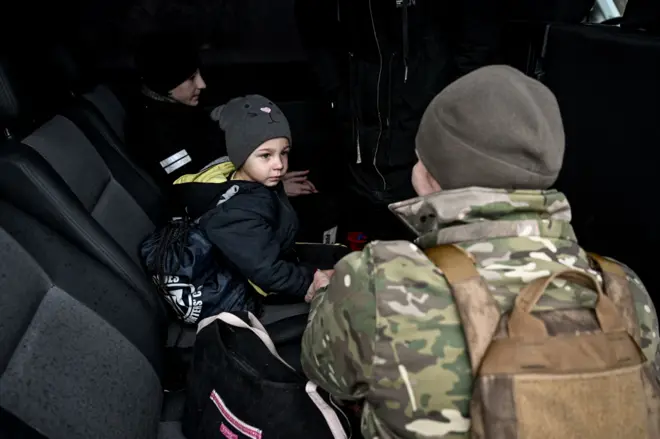 Một nữ quân nhân trò chuyện với một cậu bé nhỏ — người được các sĩ quan cảnh sát của Phòng Cảnh sát Quận Huliaipole thuộc Vùng Zaporizhzhia sơ tán khỏi ngôi làng tiền tuyến Vozdvyzhivka ở huyện Polohy, cùng với mẹ em là Anna và hai người anh em — trên chiếc xe tải của các tình nguyện viên khi gia đình chuẩn bị tiếp tục hành trình đến nơi an toàn, tại vùng Zaporizhzhia, Ukraine, ngày 19 tháng 11 năm 2025. (Ảnh: Dmytro Smolienko/Ukrinform) KHÔNG SỬ DỤNG CHO NGA. KHÔNG SỬ DỤNG CHO BELARUS. (Ảnh: Ukrinform/NurPhoto qua Getty Images)