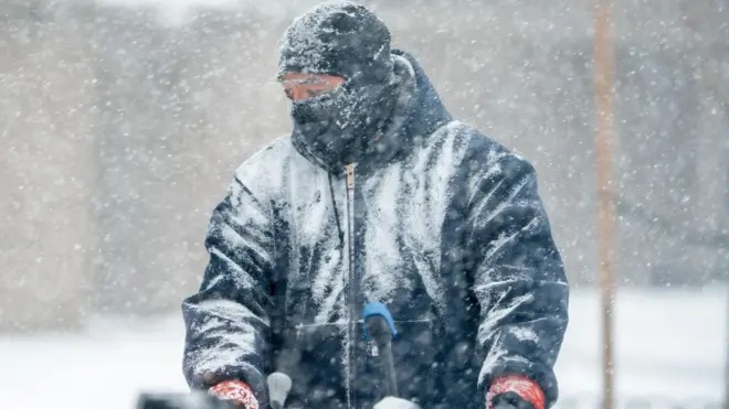 Hombre muy abrigado en plena tormenta de nieve en Nueva York, 25 de enero de 2026