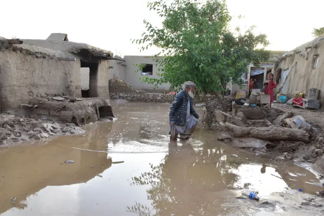 در تصویر مردی در حویلی خانه سیلزدهاش دیده میشود.
