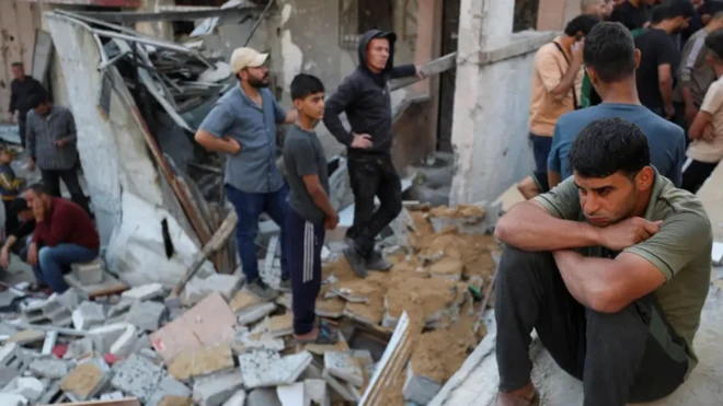 چند جوان ویرانهها را نگاه میکنند، یک جوان اندوهگین بر سر ویرانهها نشسته است