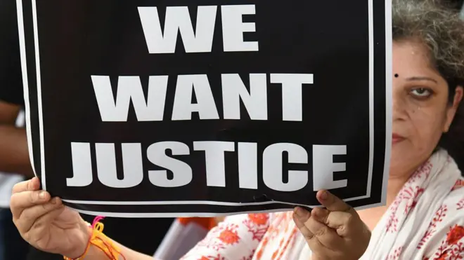 पोस्टर लिए एक महिला