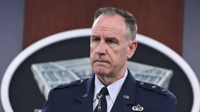 Jenerali Majoro Patrick Ryder ari mu kiganiro n'abanyamakuru. Afite umusatsi mugufi ndetse yambaye ikoti ry'igisirikare kirwanira mu mazi ririho imidali ya gisirikare. 