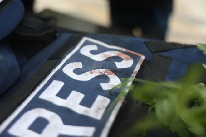 جلیقه خونین یک خبرنگار با آرم رسانه روی آن