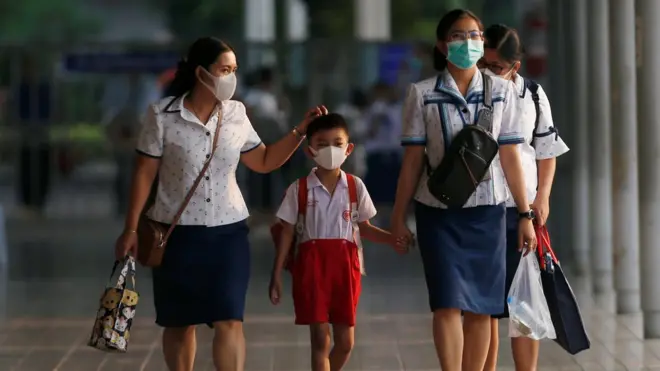 کچھ ممالک میں سکول کے بچوں کو گھر بھیج دیا گیا ہے جن میں تھائی لینڈ، ایران، عراق، اٹلی اور برطانیہ شامل ہیں۔ تصویر میں تھائی لینڈ کے شہر بینکاک میں بچے اور سٹاف سکول بند ہونے کی وجہ سے گھر واپس جارہے ہیں