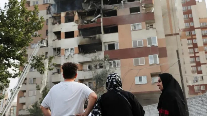 دا کسان په کوڅه کې یوه ویجاړه شوې ودانۍ ګوري.