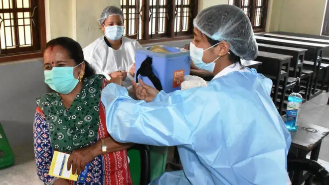 बनेपामा कोभिडविरुद्ध खोप लगाउँदै एक महिला