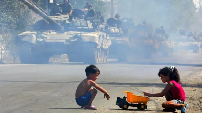 أطفال أمام دبابات 