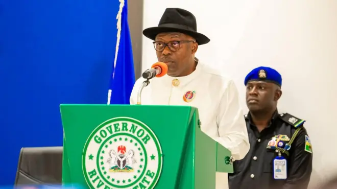 Rivers State Govnor on di podium wit policeman behind am
